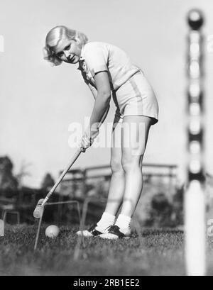 Hollywood, California:   c. 1933 Actress Mary Carlisle finishes an exciting game of croquet on the MGM lot. Stock Photo