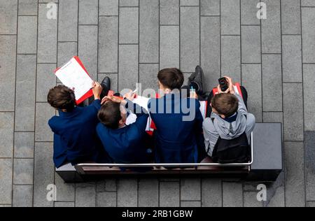Four male middle-school students working together on a geography project in Liverpool Stock Photo