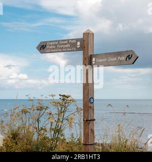 Coastal signpost from Craster to Dunstanburgh Castle, Northumberland, England Stock Photo