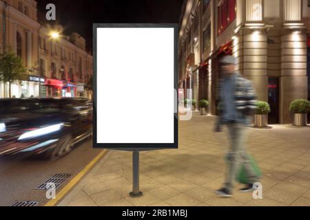 Blank street billboard at night city. Isolated with clipping path around advertising display. Stock Photo