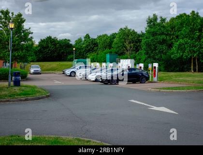 Tesla cars parked at a motorway service station at the Tesla charging points. Stock Photo