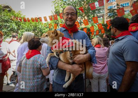 Madrid, Spain. 06th July, 2023. A man carries his pet dog in his arms wearing the traditional Pamplona scarf, during the San Fermín festival. For yet another year, the Parish of San Fermín de los Navarros in Madrid neighborhood of Chamberi has brought together Navarrese residents for the celebration of the San Fermín festivities. (Photo by David Canales/SOPA Images/Sipa USA) Credit: Sipa USA/Alamy Live News Stock Photo