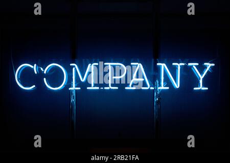 Close-up on a blue neon light shaped into the word "Company". Stock Photo