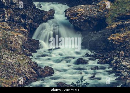 Scenic View of Tumbling Waterfall Running Through Rocky Mountains in Vestland County, Norway. Wild Nature Landscape. Stock Photo