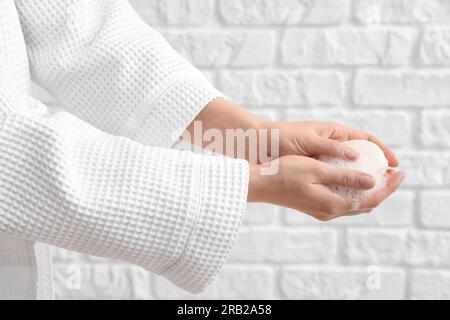 Hands with soap on white brick background Stock Photo