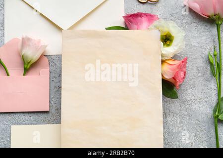 Composition with envelopes, blank cards and eustoma flowers on grey background, closeup. Wedding invitation concept Stock Photo