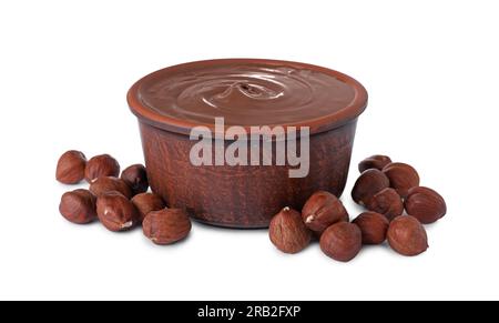 Bowl with delicious chocolate paste and hazelnuts on white background Stock Photo