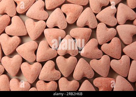 Many heart shaped vitamins for pets on beige background, flat lay Stock Photo