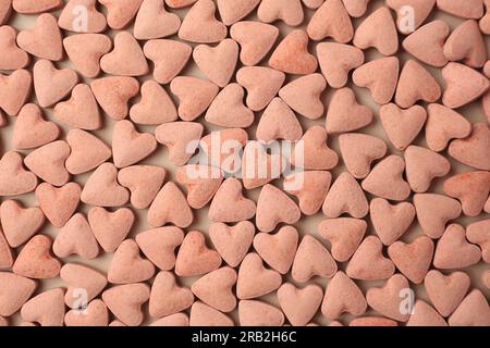 Many heart shaped vitamins for pets on beige background, flat lay Stock Photo