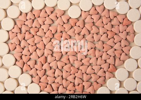 Heart made of vitamins for pets on beige background, flat lay Stock Photo