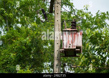 old three-phase transformer with electric pole Stock Photo