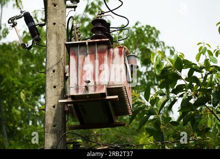 old three-phase transformer with electric pole Stock Photo