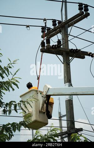 electrician using clamp stick (insulated tool) to restore power on the electric pole Stock Photo
