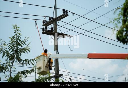 electrician using clamp stick (insulated tool) to restore power on the electric pole Stock Photo