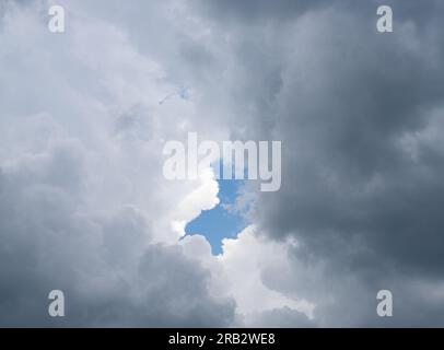 Gray and white cumulus storm clouds with a patch of blue sky. Photographed in College Station, Texas. Stock Photo