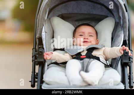 happy infant baby sitting in the stroller Stock Photo