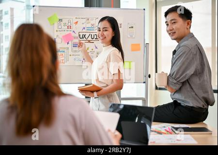 A professional tech developer team is in the meeting, planning and brainstorming on a new mobile app together. UI, UX, mobile application, tech startu Stock Photo