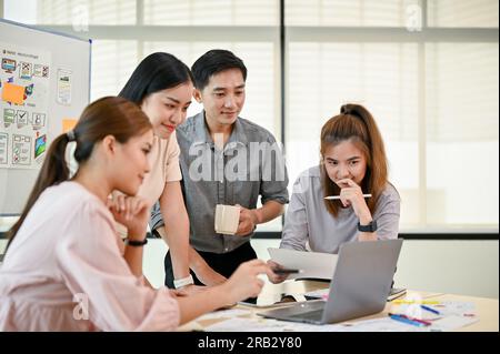 A tech developer team is in the meeting, planning and brainstorming on a new mobile app together. UI, UX, mobile application, tech startup Stock Photo