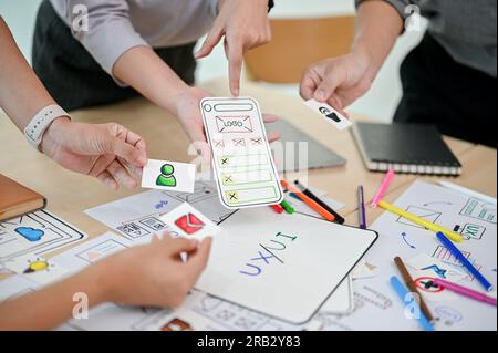 Close-up image of a mobile application developer team is in the meeting, planning and brainstorming on a new mobile app together. UI, UX, mobile appli Stock Photo
