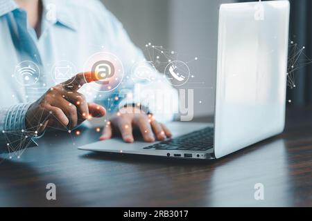 Businesswoman using laptop and touching on virtual screen contact icons such as email, address, live chat, internet wifi.Contact us or Customer suppor Stock Photo