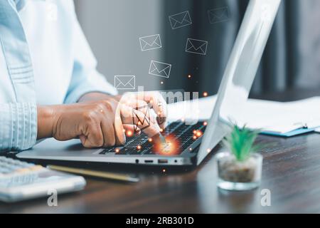 Businesswoman using laptop and touching on virtual screen contact icons such as email, address, live chat, internet wifi.Contact us or Customer suppor Stock Photo