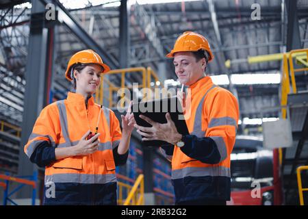 Engineer man and women worker working team together in electric train service depot transport industry factory technician mechanic staff. Stock Photo