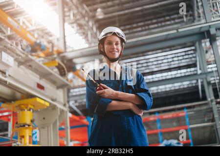 portrait engineer woman professional smart worker standing  happy smile in large industry building interior. Stock Photo