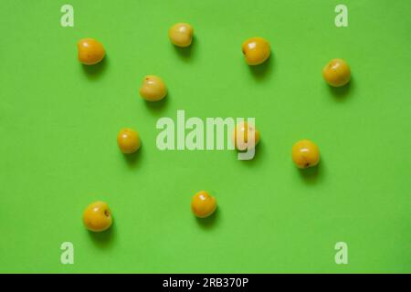 yellow cherries scattered on a colored background Stock Photo
