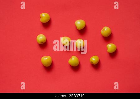 yellow cherries scattered on a colored background Stock Photo