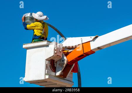Workman replacing lamps in street lighting from a cherry picker Stock Photo