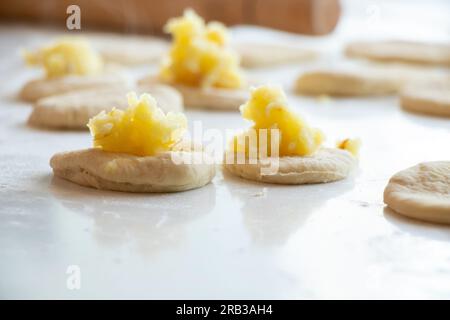 the process of making pies with potatoes at home in the kitchen on a white table, homemade habits with potatoes Stock Photo