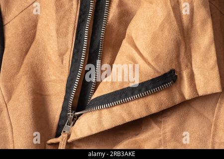 zipper on brown fabric as background close-up Stock Photo