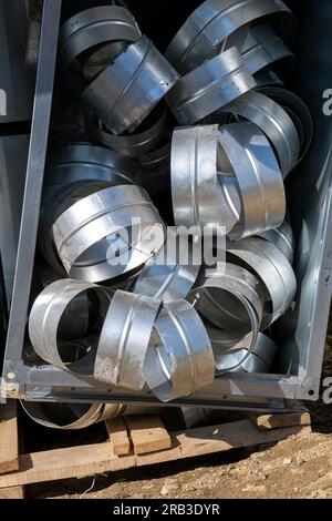 Connecting pipes for air ducts in the box. Various sheet metal air ducts in stock for installation in a building under construction. Ventilation syste Stock Photo