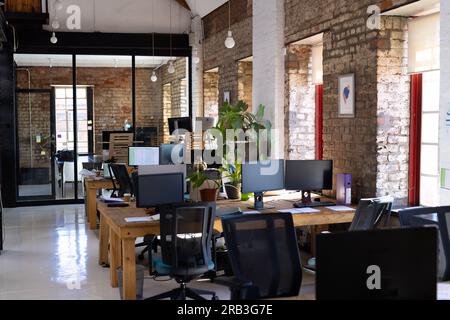 Empty creative office room with computers on desks and glass wall with notes. Business and office. Stock Photo