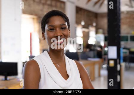 Portrait of happy african american casual businesswoman in creative office. Business, confidence and work, unaltered. Stock Photo