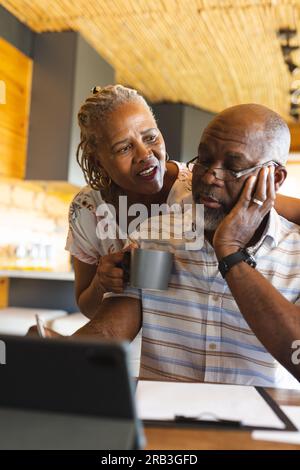 Senior african american couple doing paperwork using tablet at home. Senior lifestyle, communication, finance and retirement, unaltered. Stock Photo