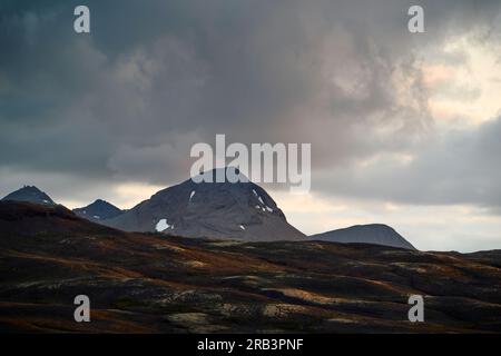 Rocky mountains under gloomy cloudy sky Stock Photo