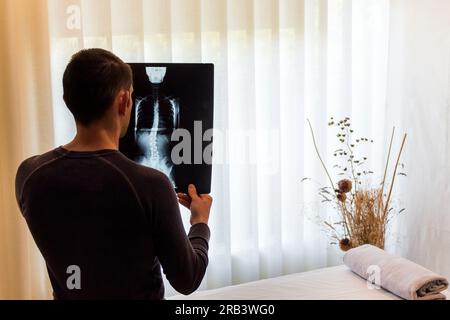 Image of a therapist analyzing a radiograph for a case study of a patient with scoliosis. Treatment and therapies to improve the patient's condition. Stock Photo