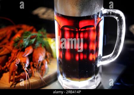 Tasty boiled crayfishes and beer on old table. Stock Photo