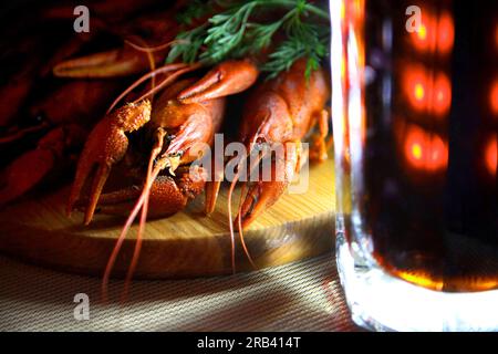 Tasty boiled crayfishes and beer on old table. Stock Photo