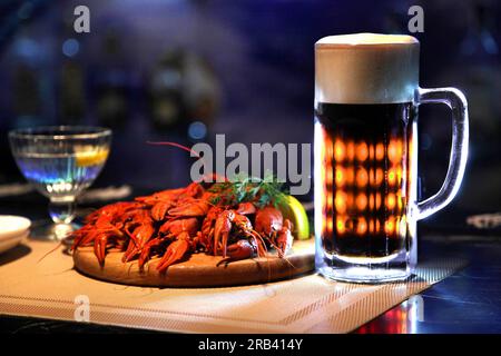 Tasty boiled crayfishes and beer on old table. Stock Photo