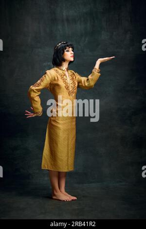 Portrait of woman in elegant egyptian headdress standing near desert ...