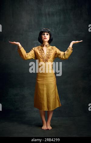 Portrait of woman in elegant egyptian headdress standing near desert ...