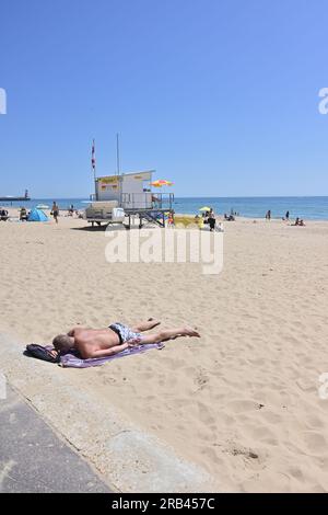 Man sunbathing on beach on hot and sunny day, Bournemouth, Dorset, England, UK, 7th July 2023, weather. Stock Photo