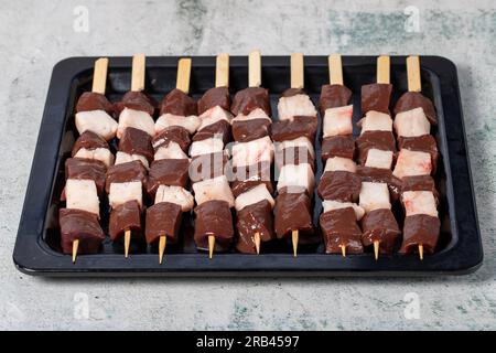 Liver skewer. Raw liver shish kebab on gray background. Turkish cuisine delicacies. Local name ciger sis Stock Photo