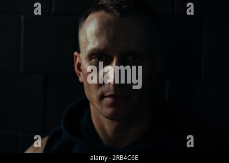 Split light portrait with light and shadow of middle age serious man. Stock Photo