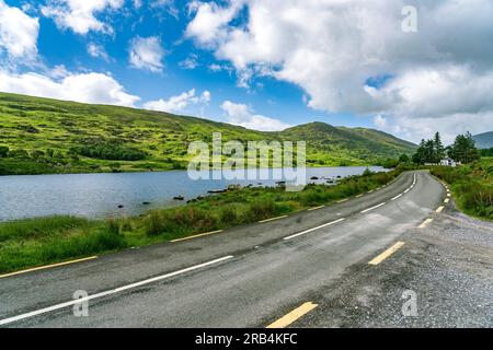 Road along the picturesque Looscaunagh Lough lake in Ireland Stock Photo