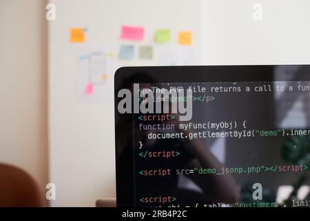 Still life of PC screen with javascript coding demo, on desk in office Stock Photo