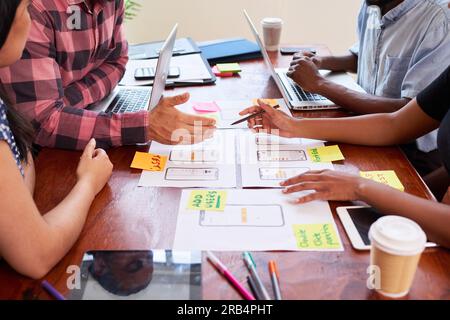 Close up of hands writing notes on mobile app layout design, coding tech Stock Photo