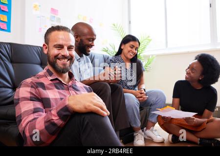 Group of diverse colleagues brainstorm together, informal meeting sit on floor Stock Photo